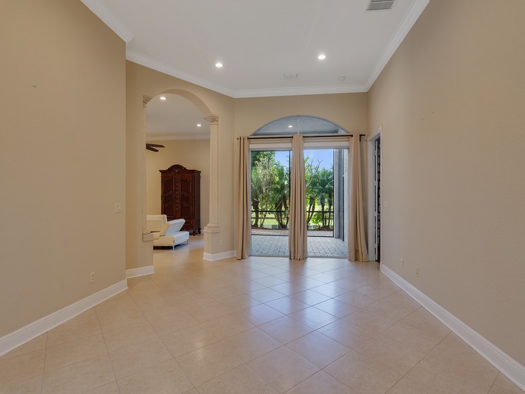Expansive room with neutral tile flooring, high ceilings, and recessed lighting