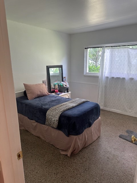 Room featuring white walls, a single window, and speckled flooring