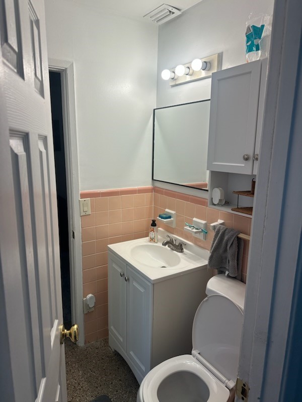 Bathroom featuring a white vanity with a basin sink, wall-mounted mirror, and white medicine cabinet