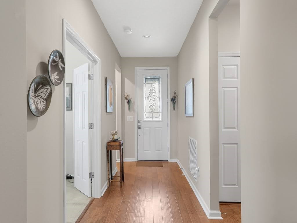 Entryway featuring wood-finish flooring, a white front door with decorative glass, and recessed ceiling lighting