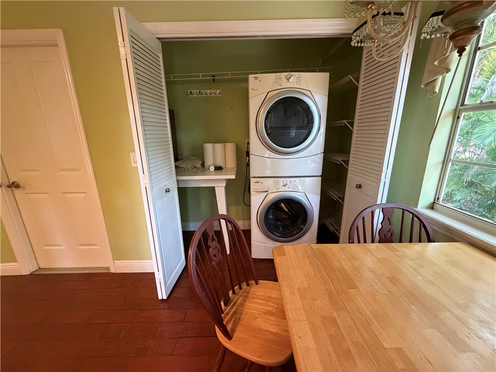Dedicated laundry closet featuring a stackable washer and dryer, louvered bi-fold doors, and integrated wire shelving