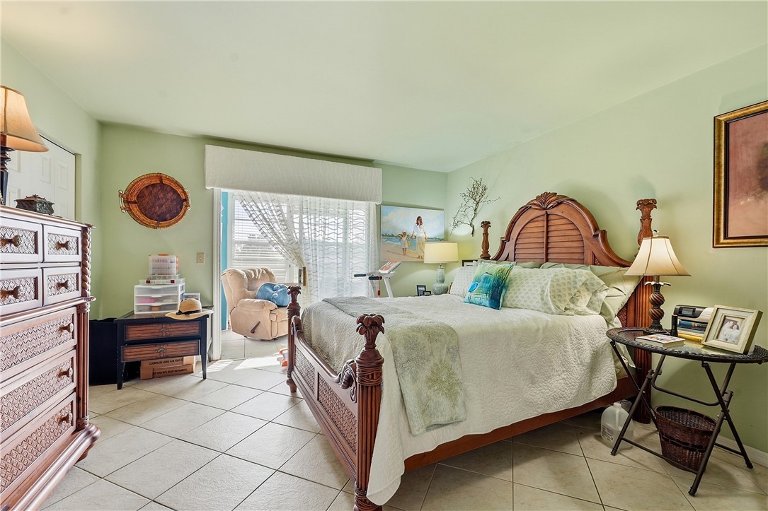 Spacious bedroom featuring light green walls and square tile flooring