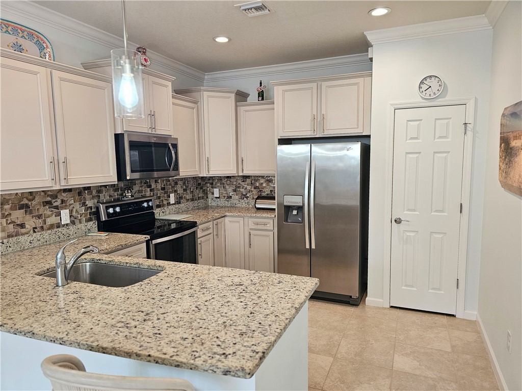 Kitchen featuring light-toned cabinetry, Pantry, Granite countertops, and a mosaic tile backsplash