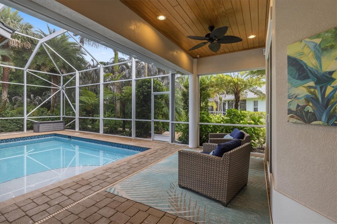 Screened lanai featuring a swimming pool, pavers, wood-finish ceiling, recessed lighting, and a ceiling fan