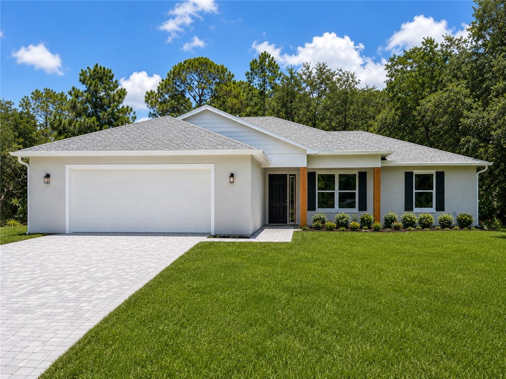 Modern single-story residence featuring a clean stucco exterior with a gabled roofline and architectural accents