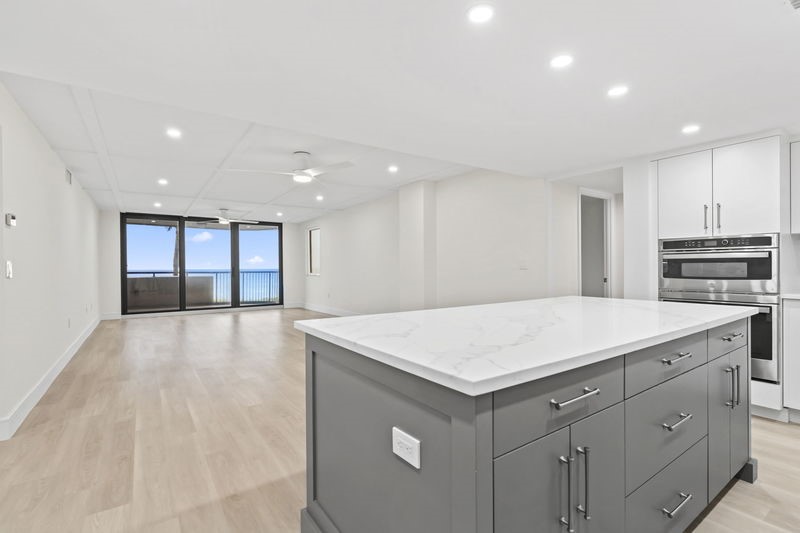Kitchen featuring a center island, gray cabinetry, a wall of windows, light wood-style floors, and recessed lighting