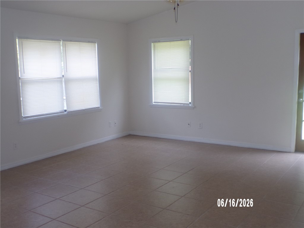 Room featuring ceramic tile flooring, white baseboards, and neutral wall tones