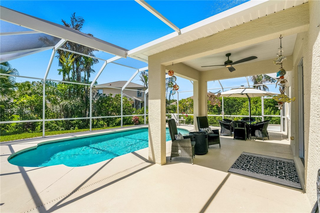 Screened-in patio with an in-ground swimming pool, covered lanai, and a ceiling fan