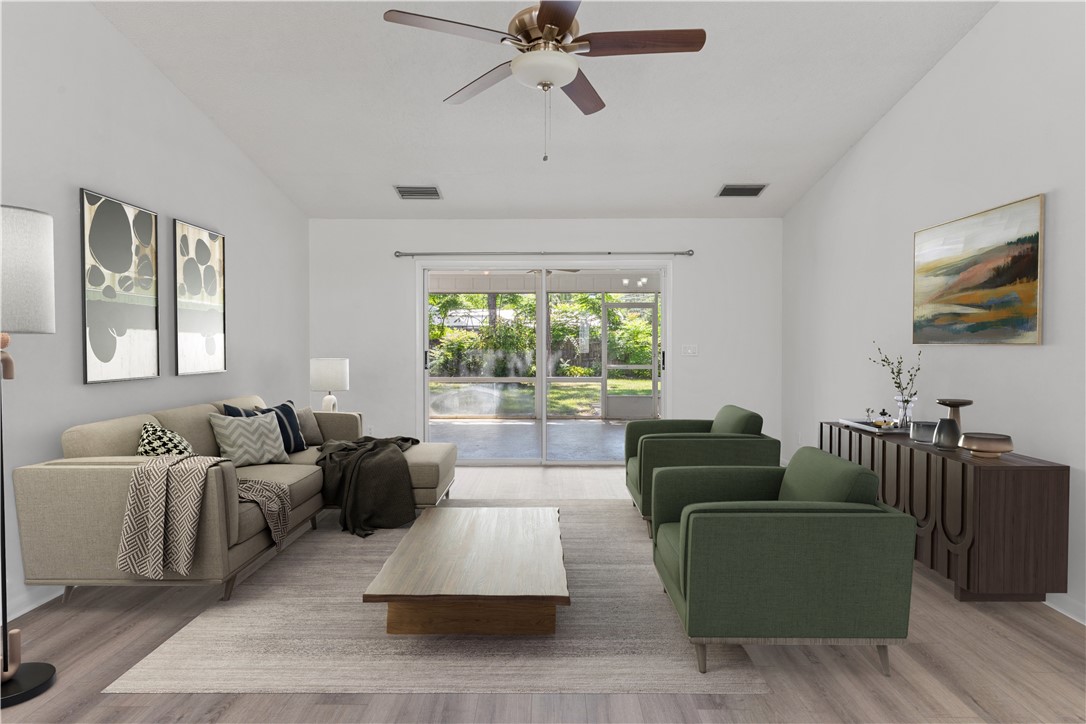 Virtually Staged-Spacious living area featuring vaulted ceilings and wood-finish flooring