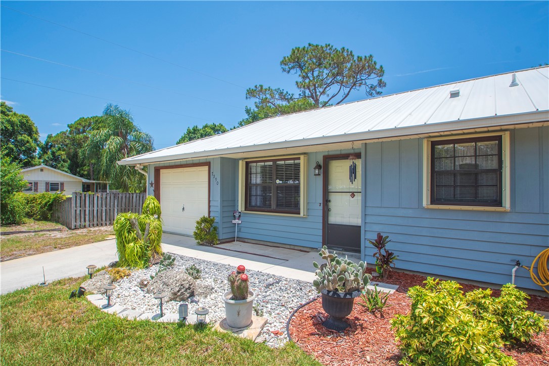 Light blue siding exterior featuring a white metal roof