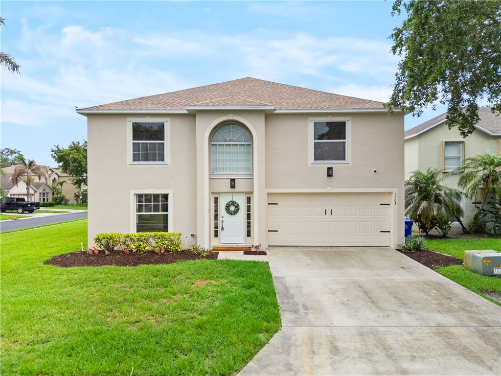 Two-story stucco exterior with an arched entryway window and a white paneled front door
