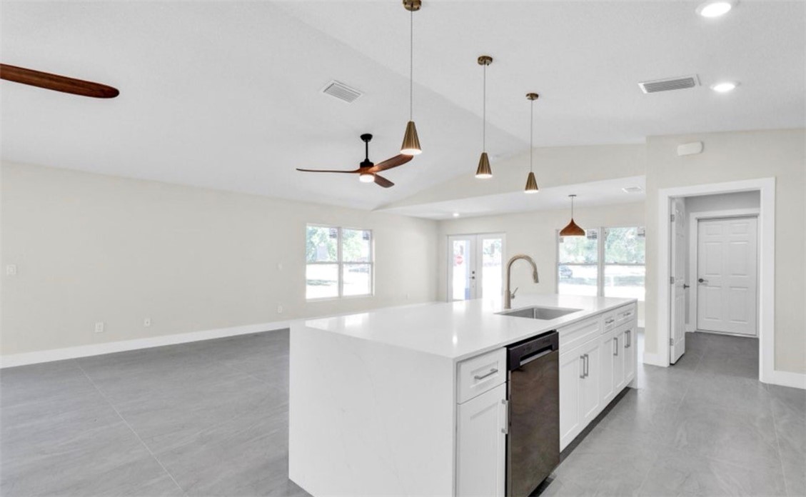 Spacious kitchen island with a white countertop and integrated sink, complemented by pendant lighting