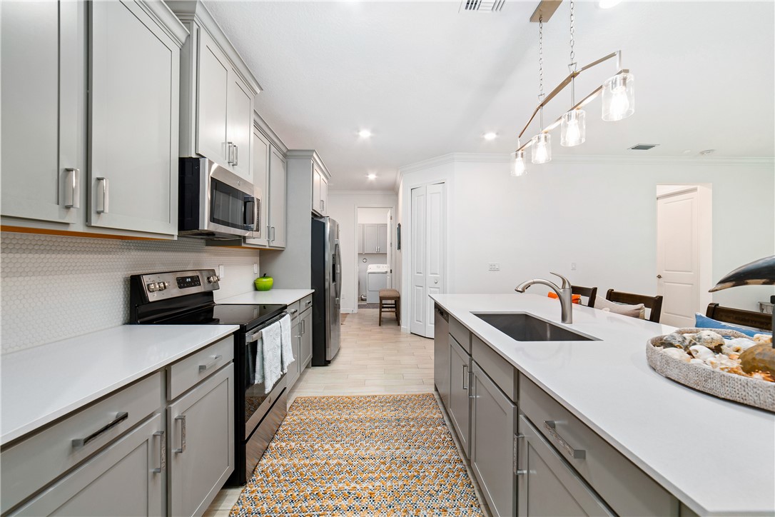 Contemporary kitchen featuring gray shaker-style cabinetry with chrome hardware