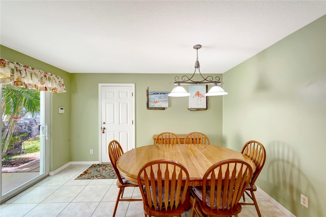 Dining area featuring tile flooring, a multi-paneled door, and sliding glass doors providing outdoor access