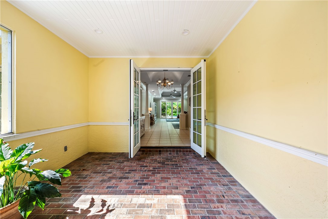 Covered patio with brick flooring and beadboard ceiling