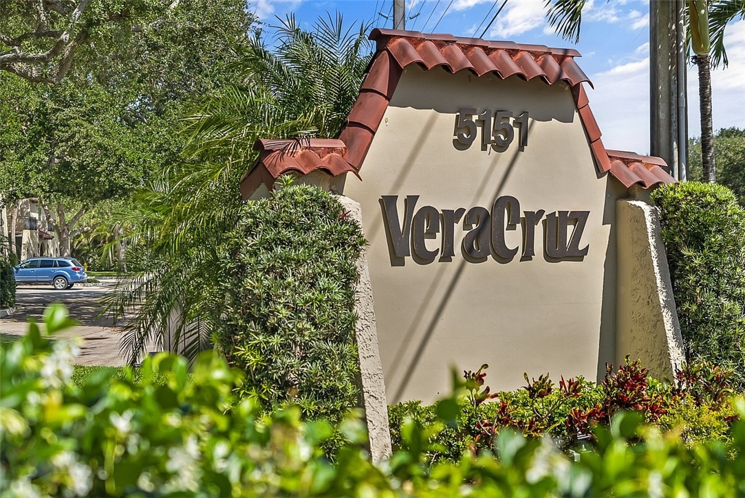 Stucco entry monument featuring a terra cotta tile cap and integrated landscaping