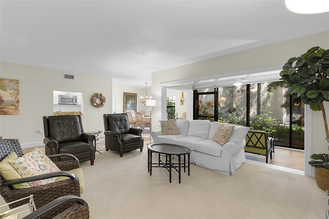 Bright living area featuring light-toned carpeting and neutral wall tones
