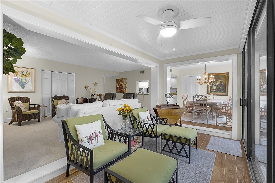 Bright sunroom featuring a white plank ceiling and wood-finish flooring