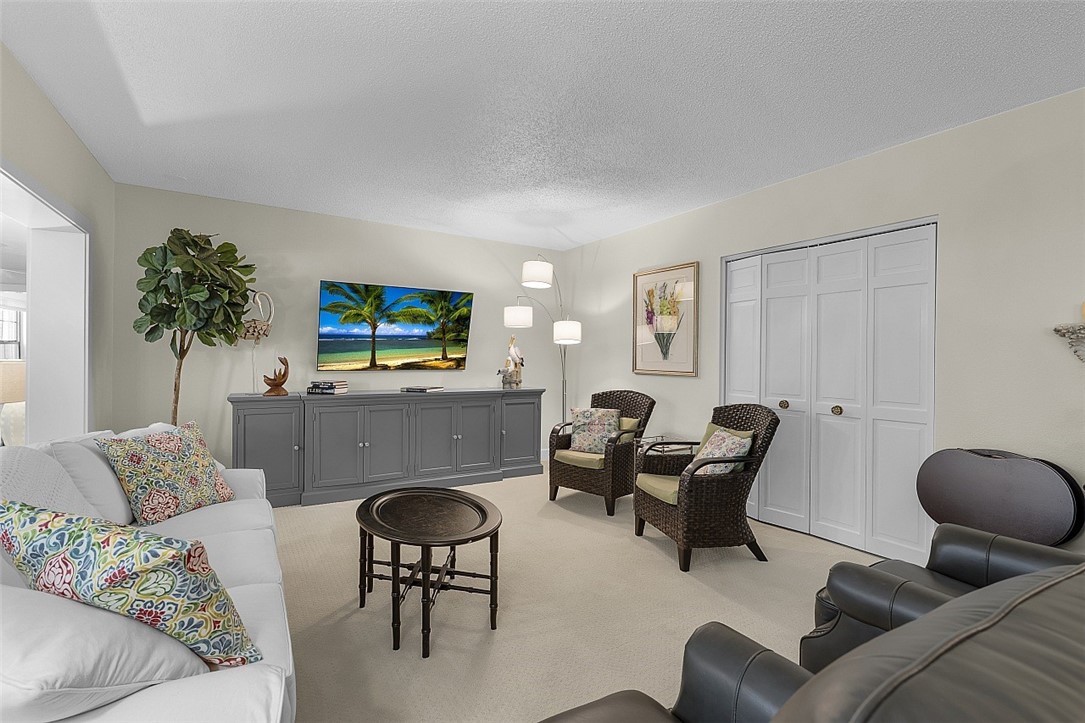 Spacious living area featuring neutral wall colors, wall-to-wall carpeting, and white bi-fold closet doors