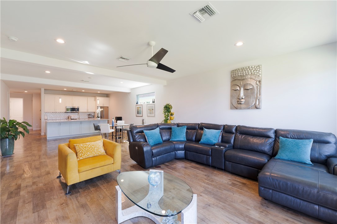 Open-concept living area featuring wood-finish flooring, recessed lighting, and a contemporary ceiling fan