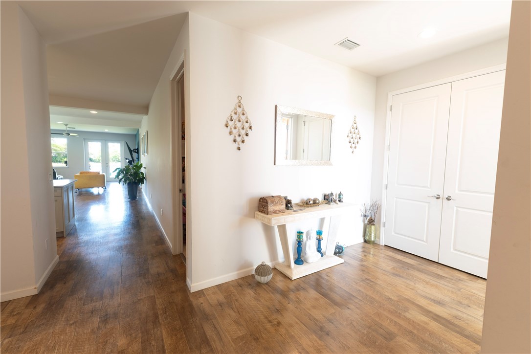 Entryway featuring wood-finish flooring, white walls, and bright white double-panel doors
