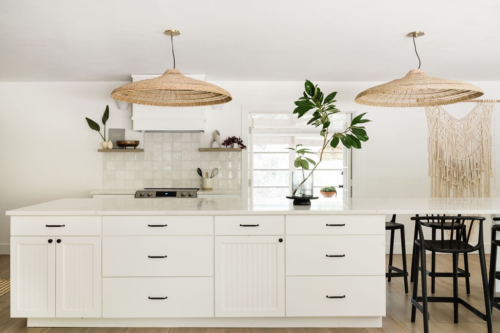 Kitchen featuring a spacious center island with ample cabinetry, quartz countertops, a built-in range, and two woven pendant lights