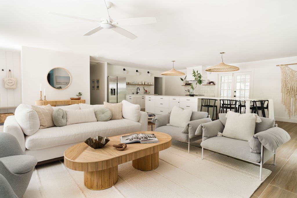 Open-concept living space featuring light wood-finish flooring and a white ceiling fan