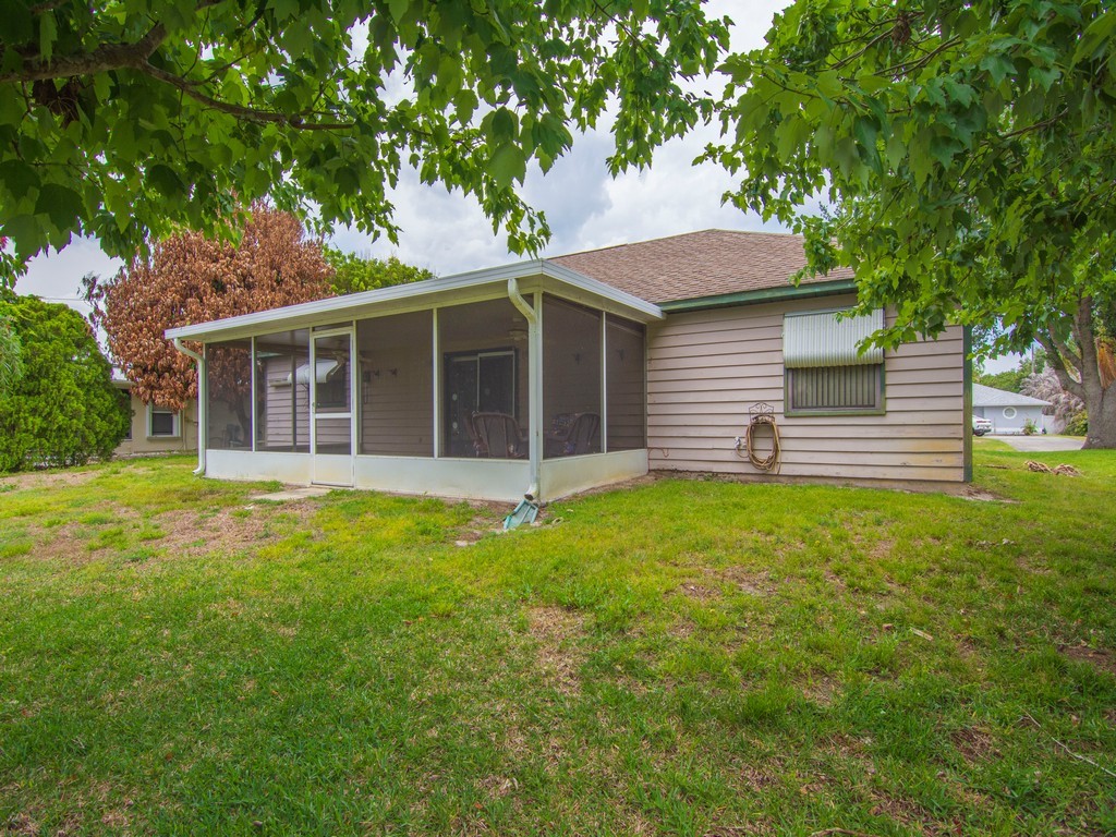 Spacious screened-in patio featuring a concrete slab and direct access to the side yard