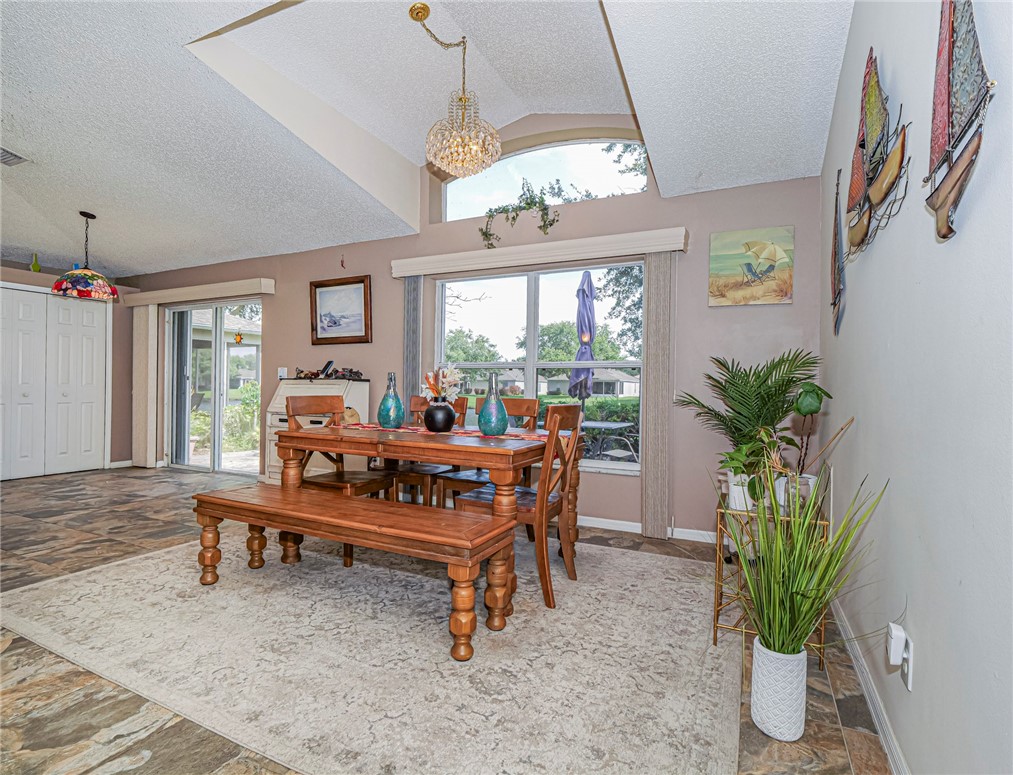 Vaulted ceilings with a decorative chandelier illuminate this dining area
