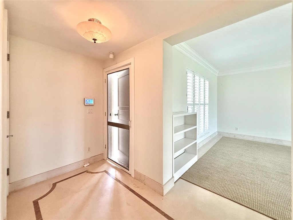 Entryway featuring patterned stone flooring, a flush-mount ceiling light fixture, and a built-in shelving unit