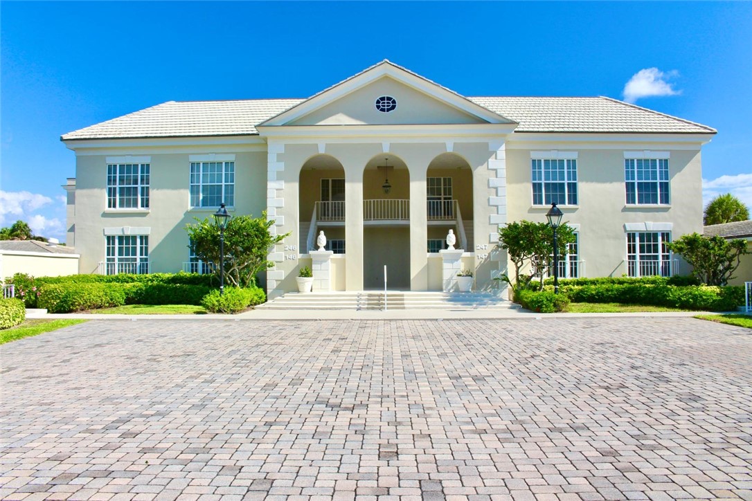 Stucco exterior featuring a tiled roof and multiple large windows