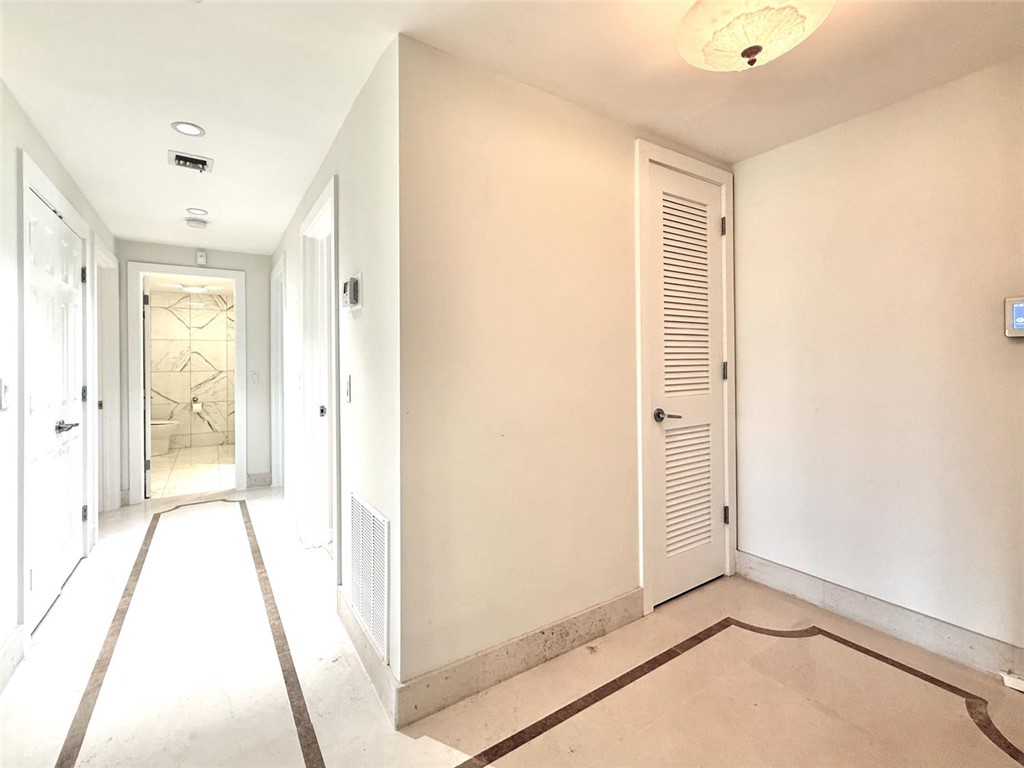 Hallway featuring recessed lighting, a decorative flush-mount ceiling light, and light-toned walls