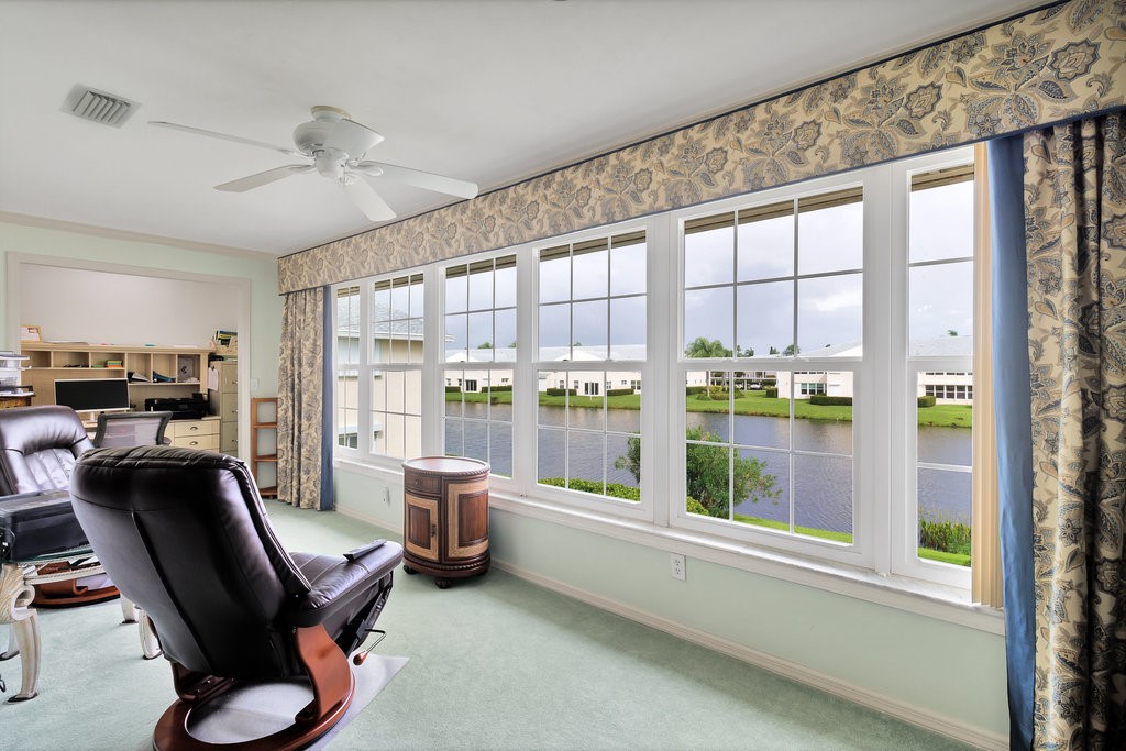 Bright interior space featuring a wall of multiple paneled windows overlooking a body of water