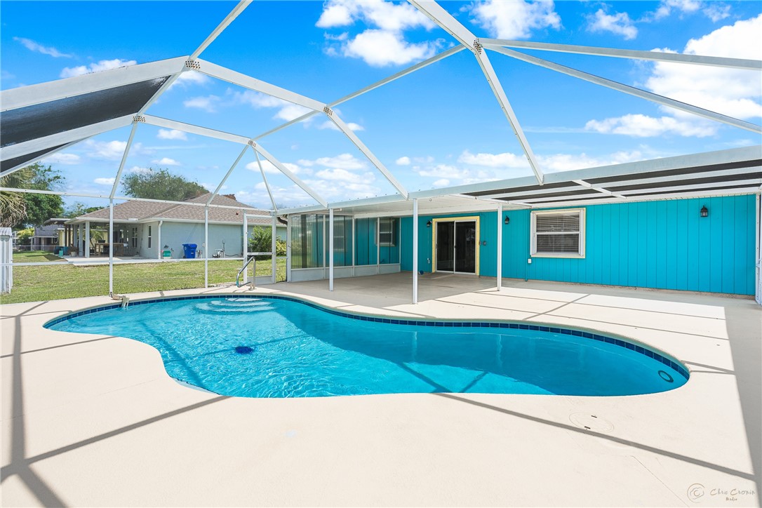 Screen-enclosed swimming pool with a freeform shape and integrated steps