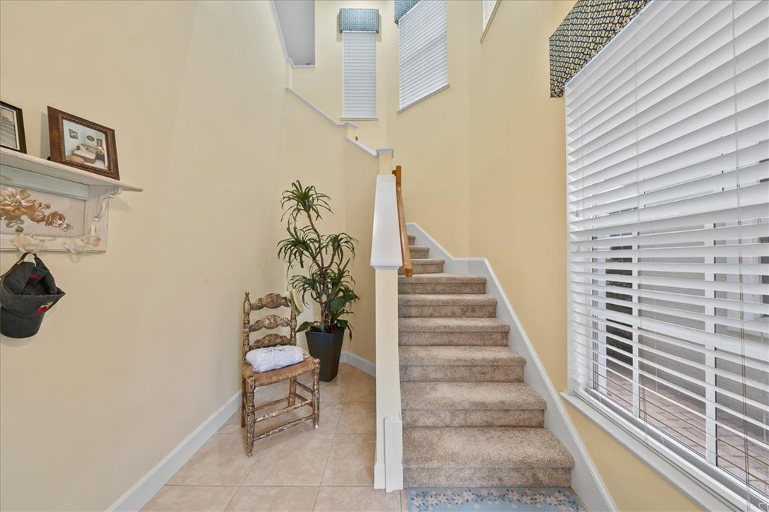 Multi-level staircase with carpeted treads and a wooden handrail