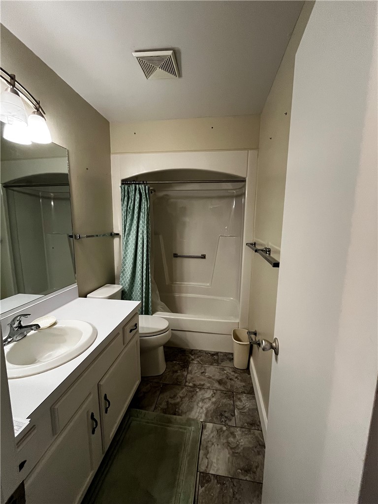 Full bathroom featuring a white vanity with integrated sink, overhead vanity lighting, framed mirror, and a white tub/shower combination