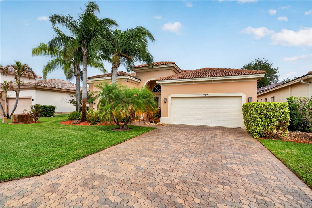 Mediterranean-style residence featuring a stucco exterior, barrel tile roof, and an integrated two-car garage