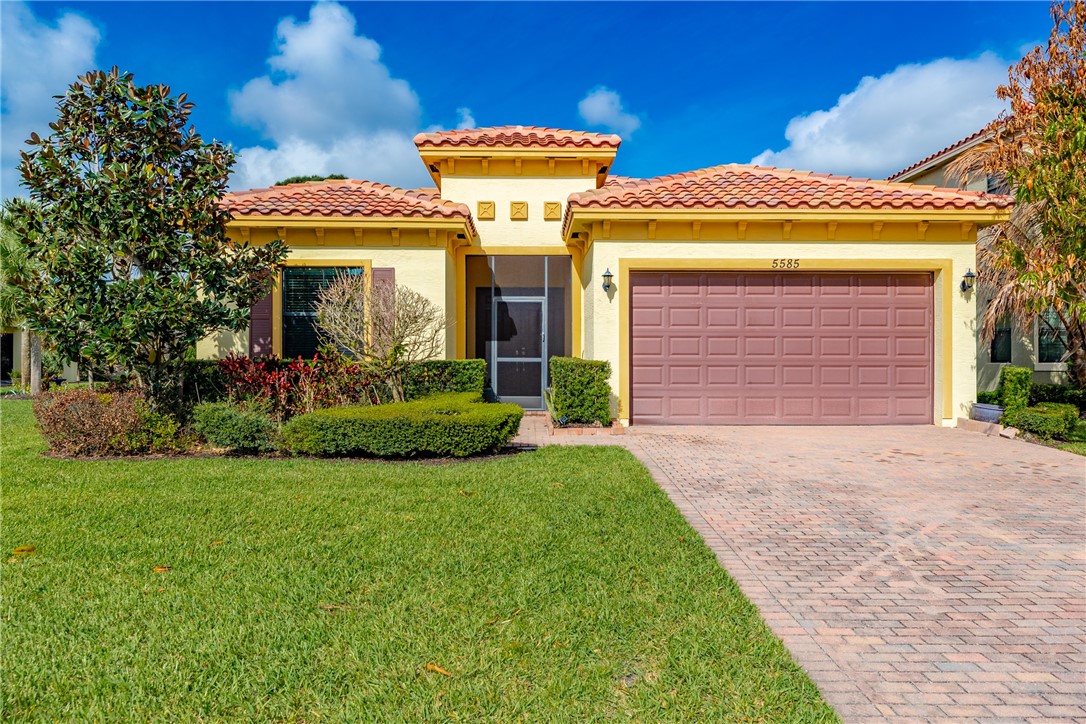 Mediterranean / spanish home featuring stucco siding, decorative driveway, a garage, and a front yard