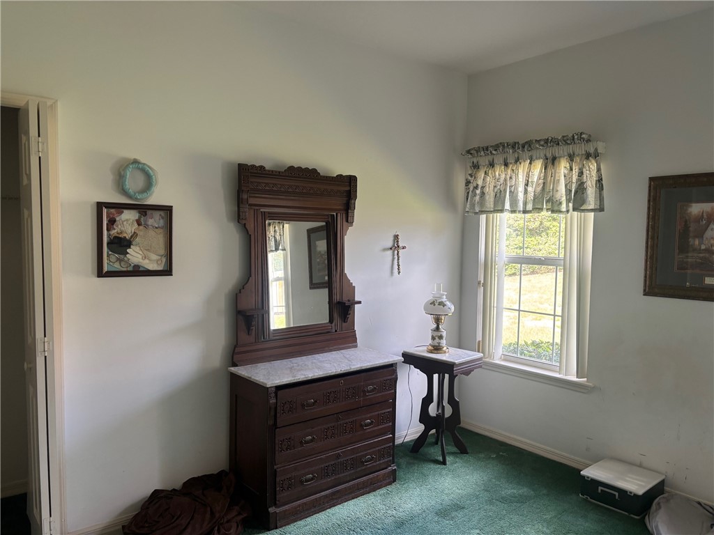 Bedroom with dark colored carpet and baseboards