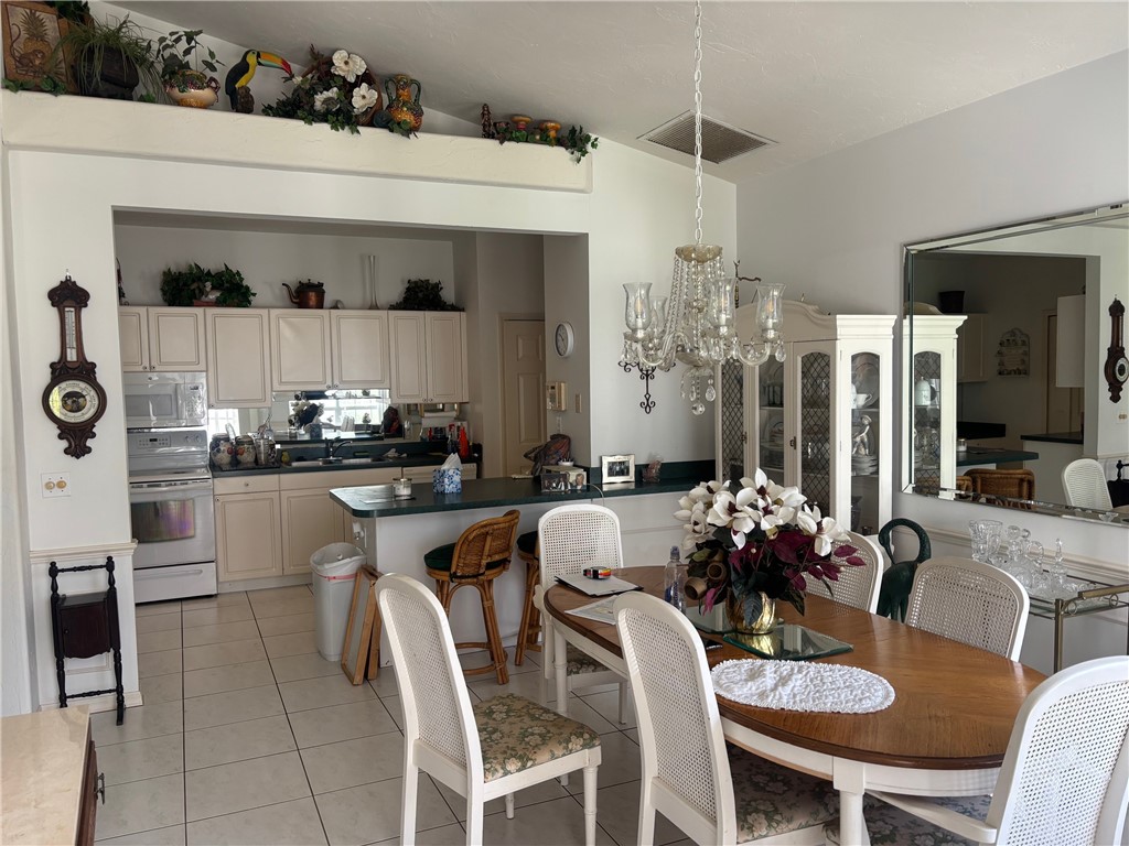 Dining space featuring suspended lighting and light tile patterned floors