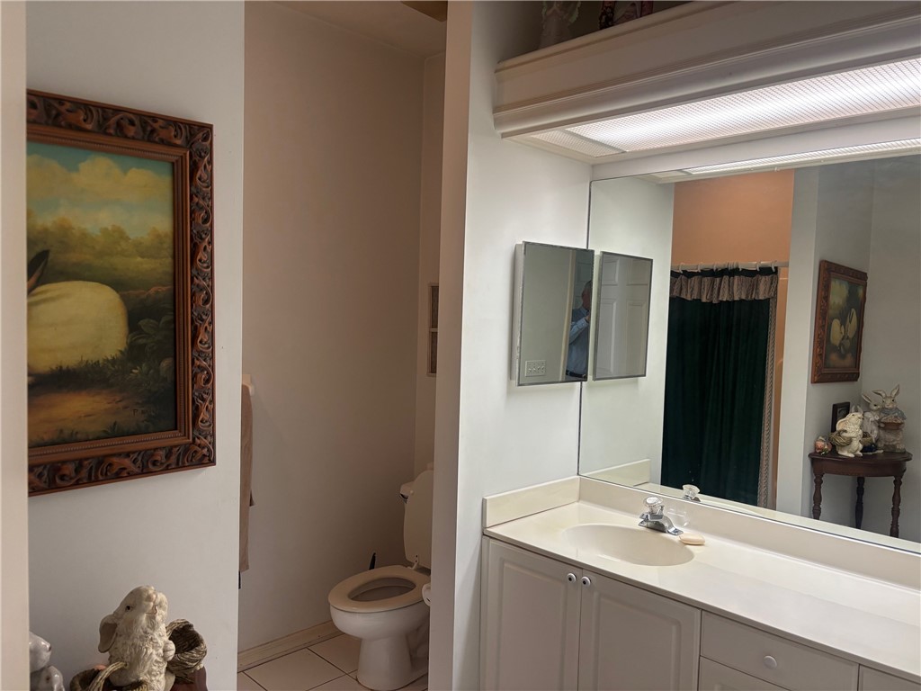 Full bath featuring a shower with curtain, light tile patterned flooring, and vanity