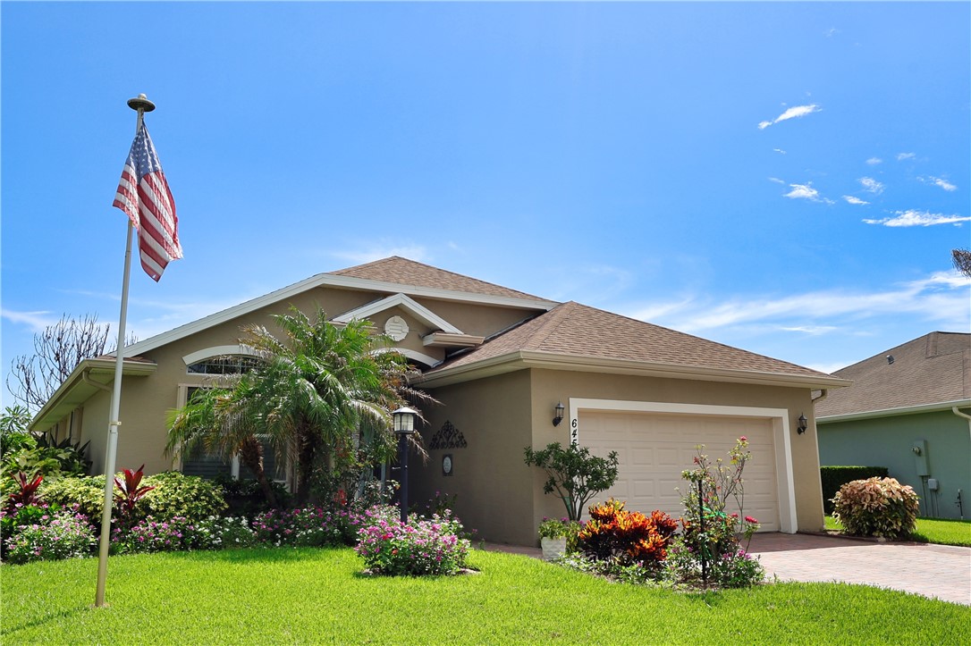 Single-story residence featuring stucco exterior, shingle roofing, and an attached two-car garage