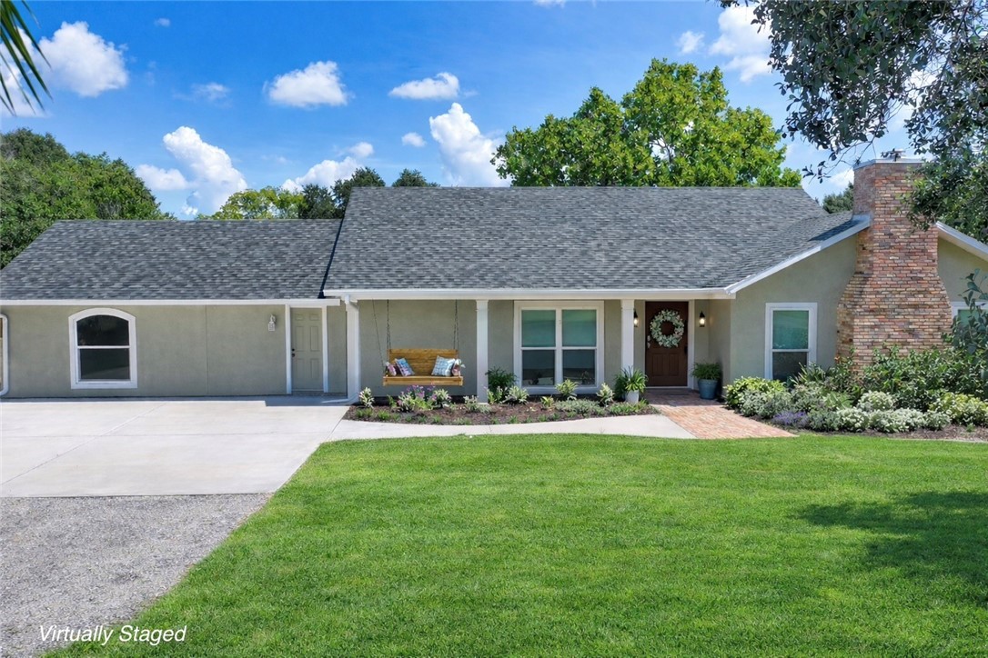 Beautifully maintained home featuring stucco siding, a front lawn, concrete driveway, and a shingled roof
