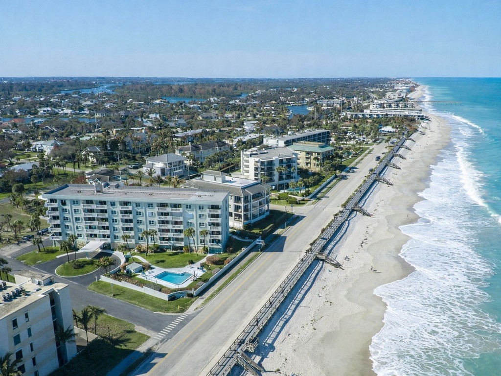 Aerial view of expansive coastline and apartment complex / building