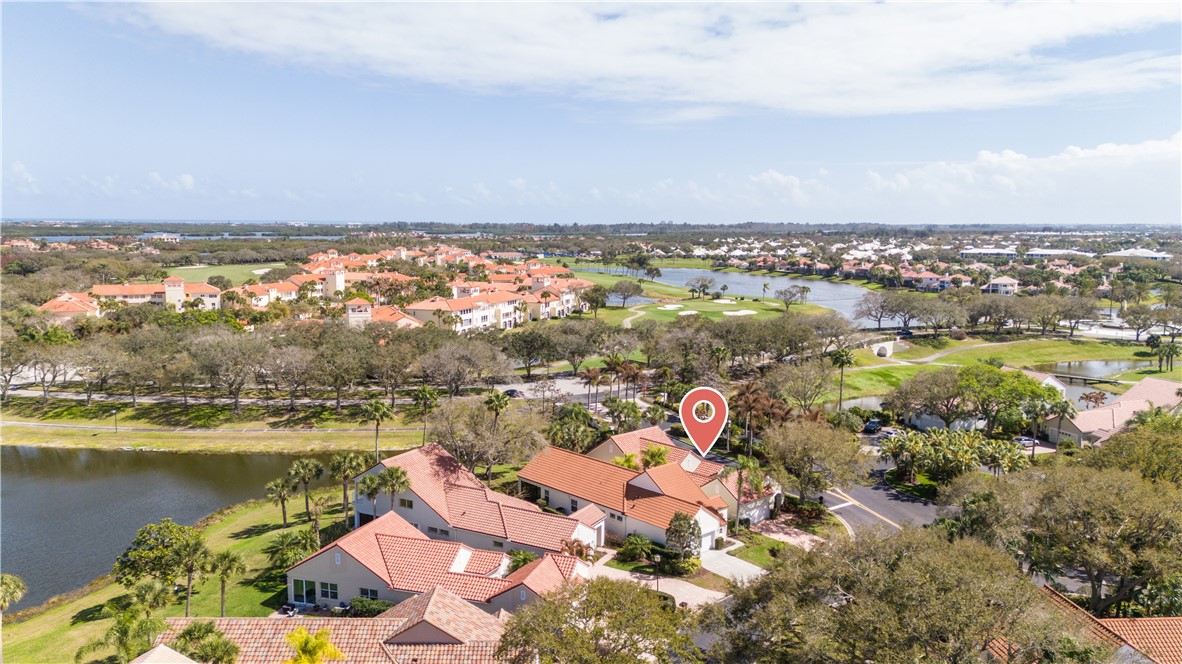 Aerial view of residential area with a nearby body of water and a golf course