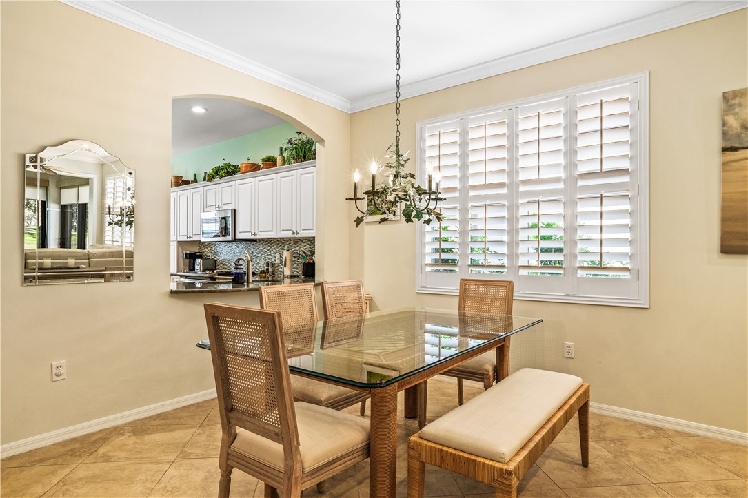 Dining space featuring healthy amount of natural light, crown molding, hanging lights, and light tile patterned floors