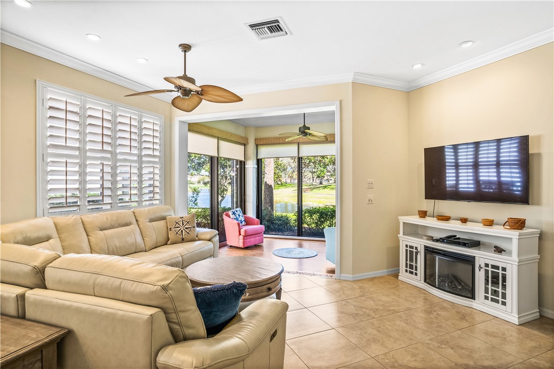 Living area featuring crown molding, ceiling fan, light tile patterned flooring, and recessed lighting