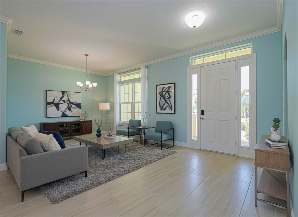 Foyer featuring ornamental molding, hanging lights, and light wood finished floors