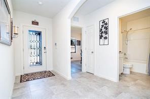 Entryway with arched walkways and light tile patterned flooring