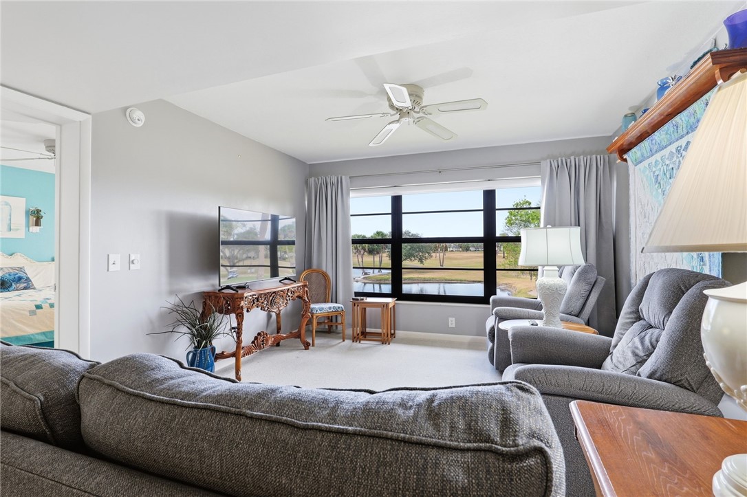 Living area with ceiling fan, healthy amount of natural light, and carpet